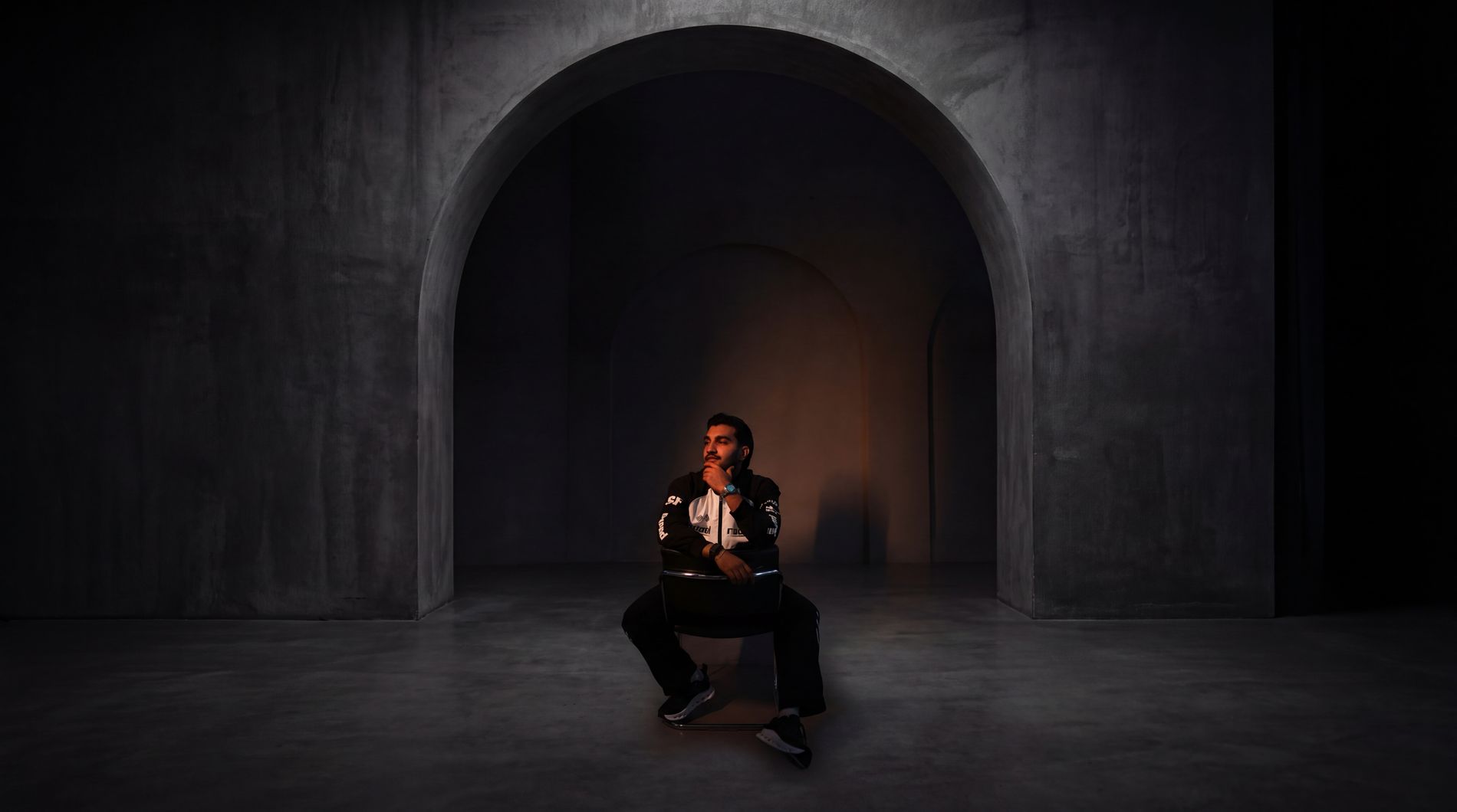 Sultan Bhatti seated beneath a dramatic concrete arch