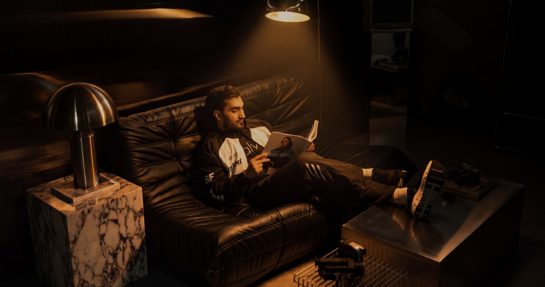 Sultan Bhatti reading a magazine under warm cinematic light