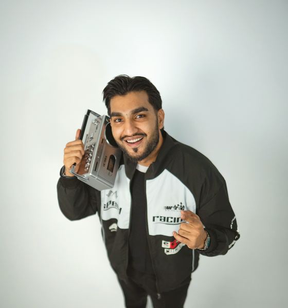 Sultan Bhatti smiling with a boombox in a bright studio