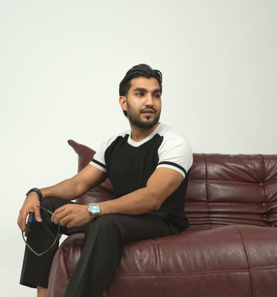 Sultan Bhatti seated on a burgundy sofa