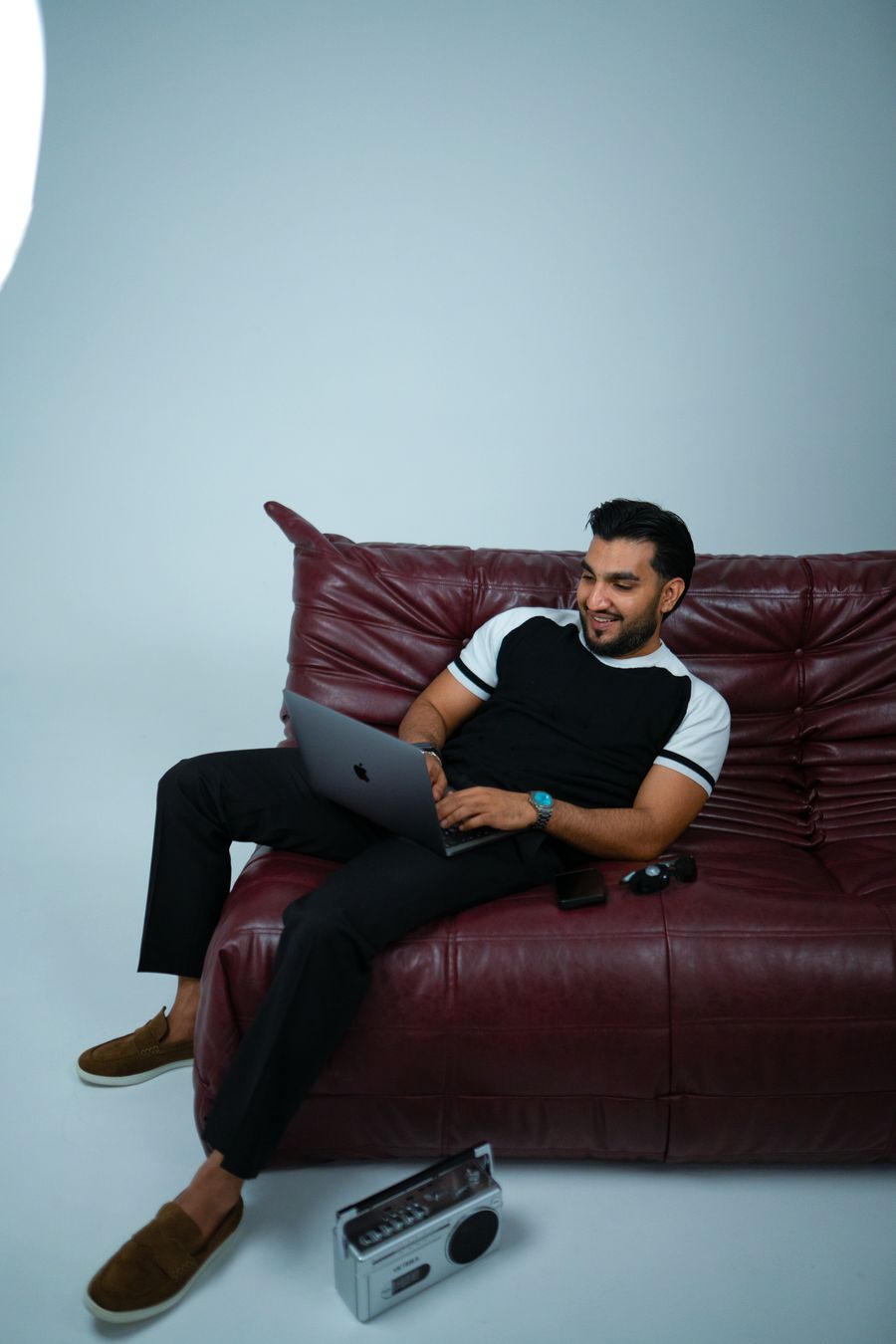 Sultan Bhatti holding a boombox on his shoulder, full length studio portrait